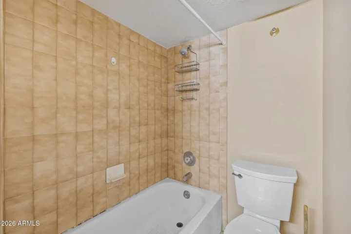 Clean primary bathroom with tiled tub/shower and neutral finishes.