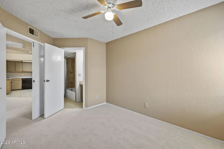 Secondary bedroom with double doors and attached bathroom.