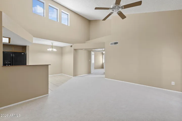 Open great room with vaulted ceilings, new carpet, and natural light.