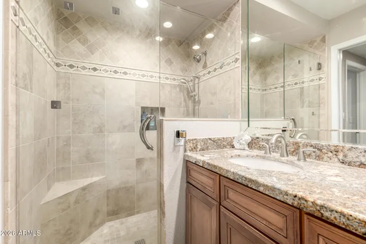 Beautiful tiled walk in shower and large granite vanity in downstairs en-suite bathroom.