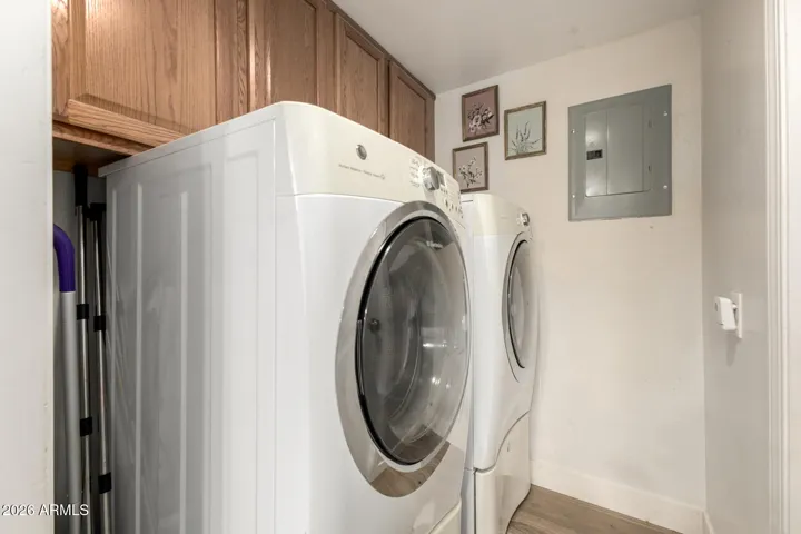 These large capacity washer and dryer stay with the home! Laundry room has additional cabinets for storage and a walk in storage room, with door, under the staircase, for additional storage.