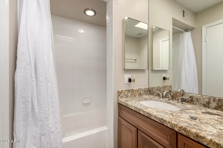 Updated upstairs bathroom with granite counters and tiles surround bathtub.