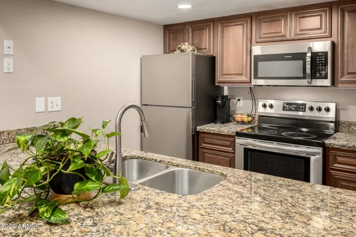 Custom bar has granite counters, a wine refrigerator and tons of cabinets for storage.