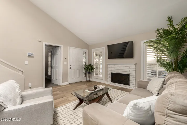 Spacious living room with wood burning fireplace and lots of light.