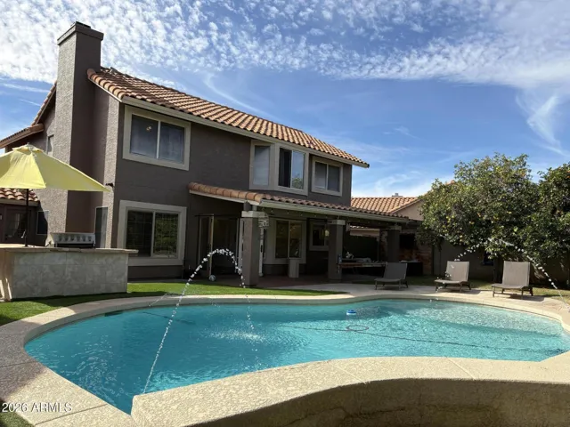 DREAM backyard with custom play pool, waterfall and large Baja step. Total privacy.