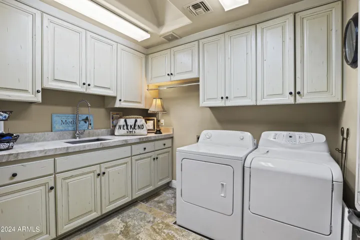 Main level laundry with lots of cabinets.