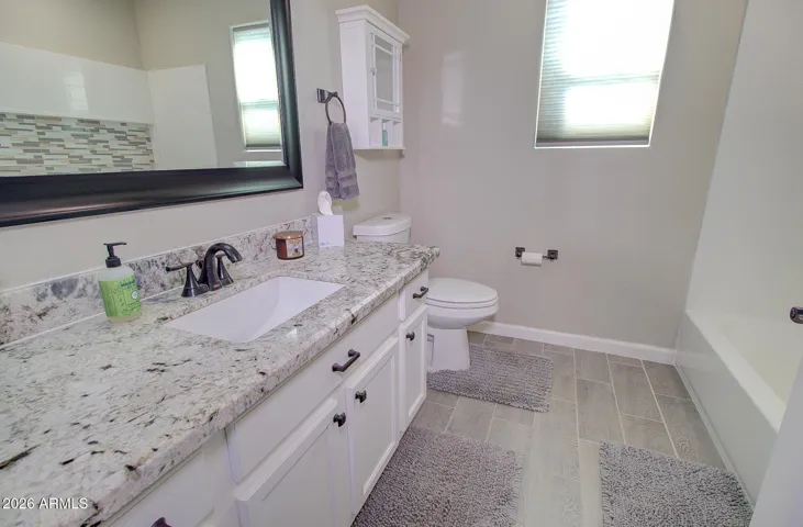 Updated guest bathroom. tub, tile surround, granite counters and tile flooring