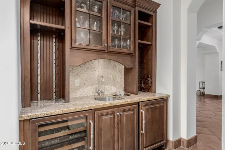 Wow. The Custom Cabinetry Continues to the Butler's Pantry with Sink, Wine Rack ,Beverage Fridge and Counter Space!