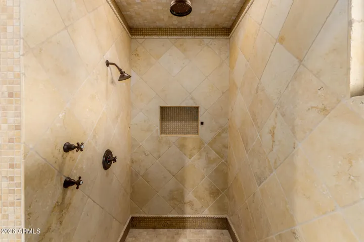 There are 2 Separate Walk In Shower Stalls with tiles and stone detail and Upgraded Faucets.