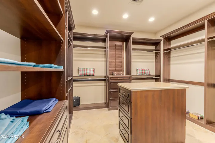 Primary Bedroom comes with 2 Separate Walk In Closets. This is Closet 1 with Custom Made with Shelves, Center Island with drawers.