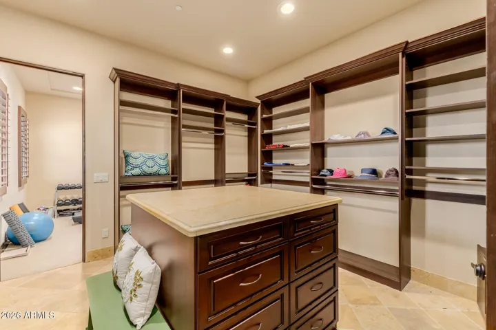 Primary Bedroom comes with 2 Separate Walk In Closets. This is Closet 2 with Custom Made with Shelves, Center Island with drawers.