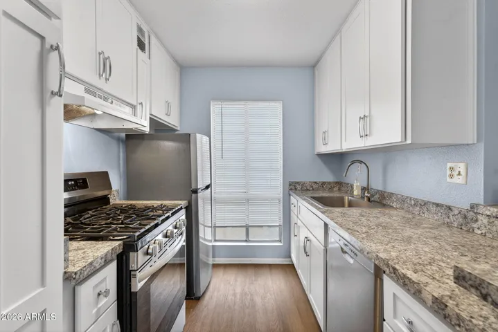Kitchen with gas stainless steel range.