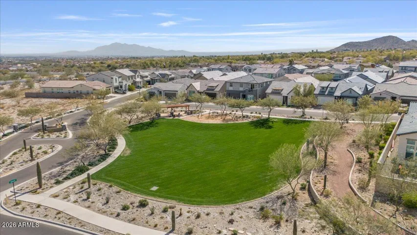 An aerial perspective highlighting the nearby park only a couple footsteps out the front door, community gate, and the home’s close proximity.
