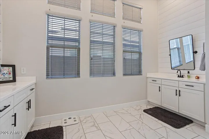 A spacious primary bathroom featuring dual vanities and a clean, functional layout.