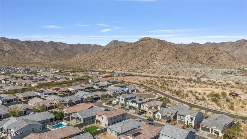 A sweeping aerial view of the Verrado Highlands community, highlighting nearby open space, trails, and the surrounding mountain scenery.
