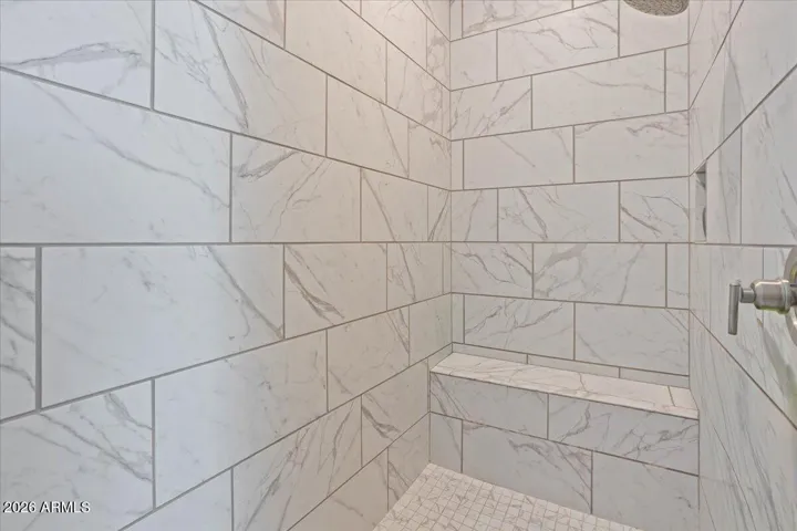 A spacious walk-in shower with neutral finishes and a clean, modern look.