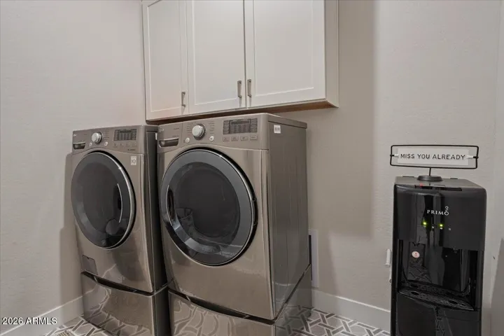 A dedicated laundry room with upper cabinets and plumbing in place for a utility sink.