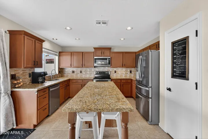 Stainless steel appliances, warm granite countertops, island with bar top seating, pantry, & recycle center.