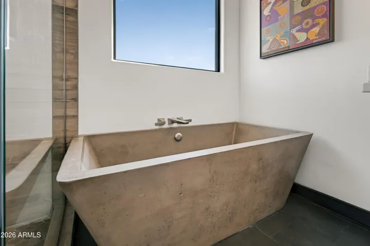 Spa-Inspired Bath: The primary bathroom is a retreat in itself, featuring a luxurious concrete tub, a separate shower, and a clean, modern vanity setup for your daily routine.