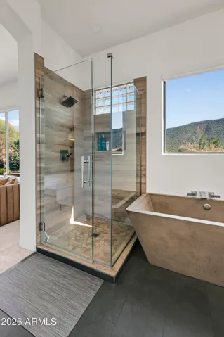 Spa-Inspired Bath: The primary bathroom is a retreat in itself, featuring a luxurious concrete tub, a separate shower, and a clean, modern vanity setup for your daily routine.