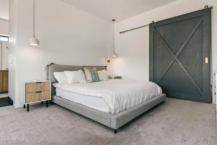 Elegant Entrance: Make a stylish statement with the custom barn door that leads into the private primary suite, adding a touch of rustic charm to the modern layout.
