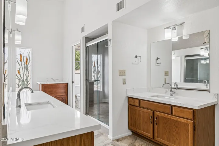 Owner's suite bath with upgraded counters, split sink layout, enclosed water closet, extra large shower