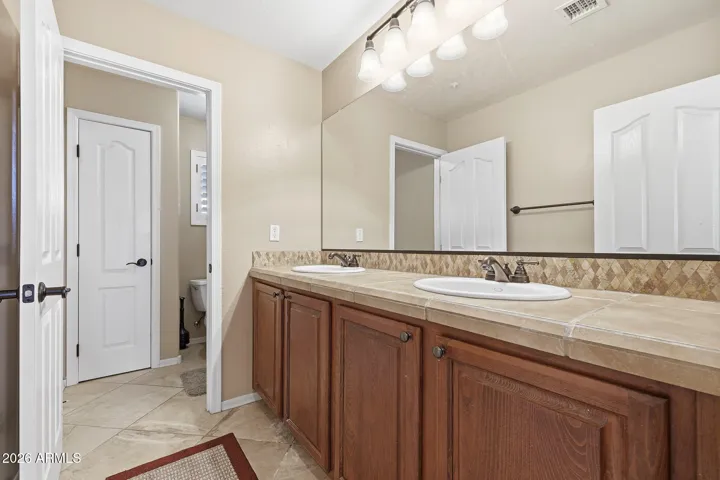 Full Bath 2 with dual sinks and separate tiled tub/toilet area.