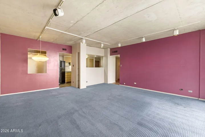 Spacious open-concept layout with authentic mid-century character and pass-through window to kitchen and flexible multi-use space.