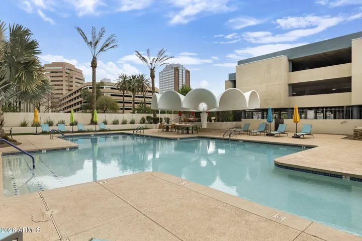 Heated community pool framed by signature architectural canopy and landscaped courtyard.