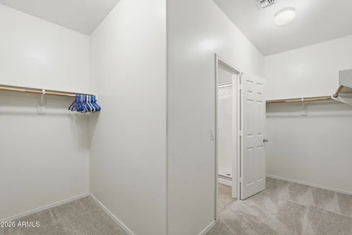 Primary walk-in Closet with walkthrough to laundry room.