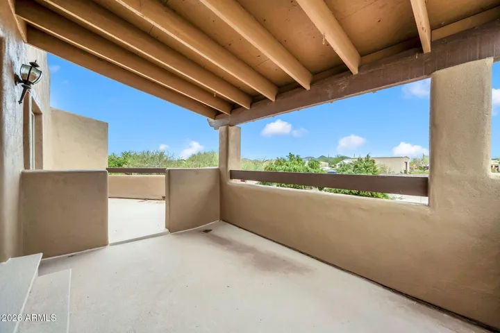 Balcony off upstairs primary bedroom with extended uncovered area