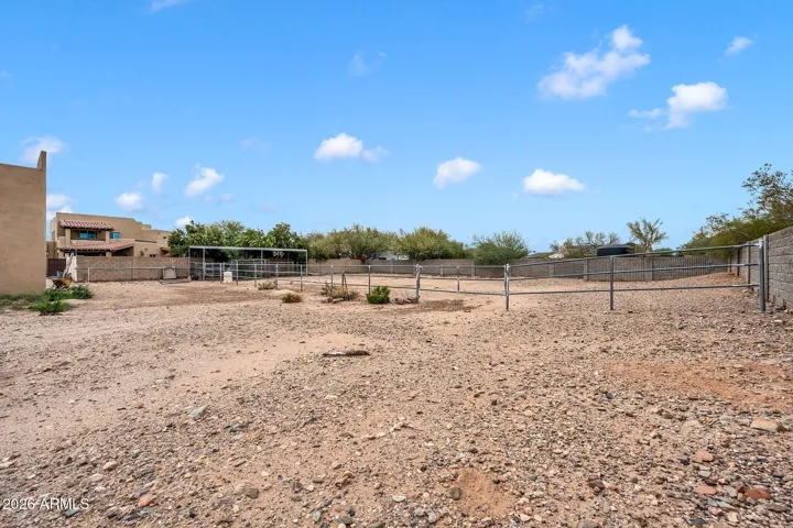 Horse stalls and property beyond fenced backyard