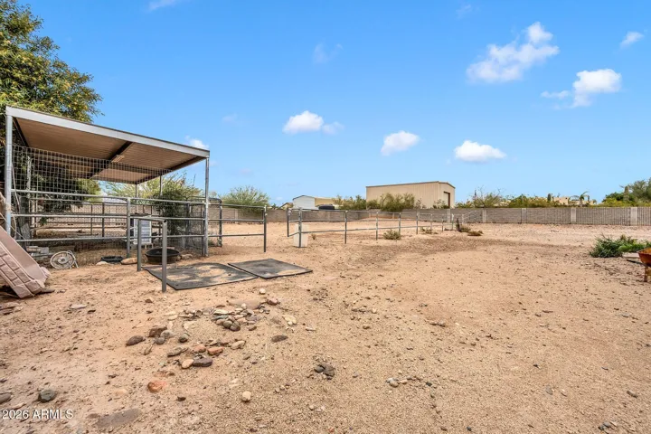 Horse stalls and property beyond fenced backyard