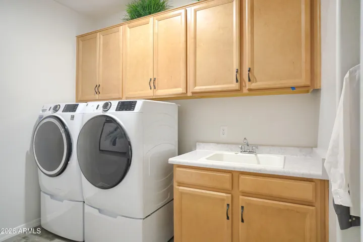 LAUNDRY ROOM COMPLETE WITH APPLIANCES, SINK AND OVER HEAD CABINETS.
