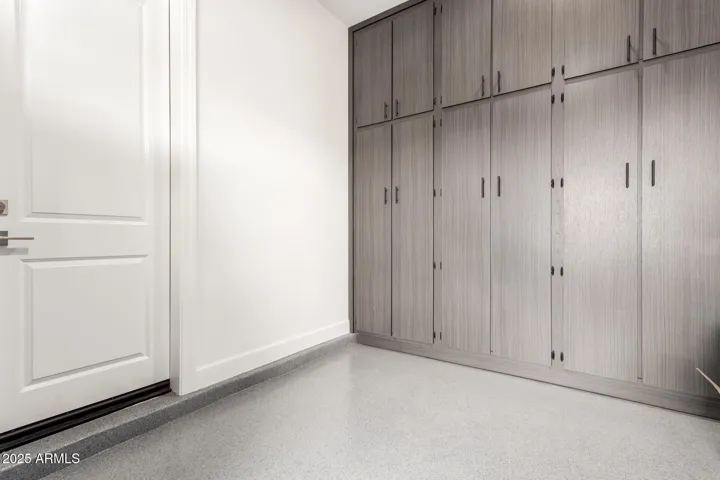 Single car garage also has floor to ceiling custom cabinets