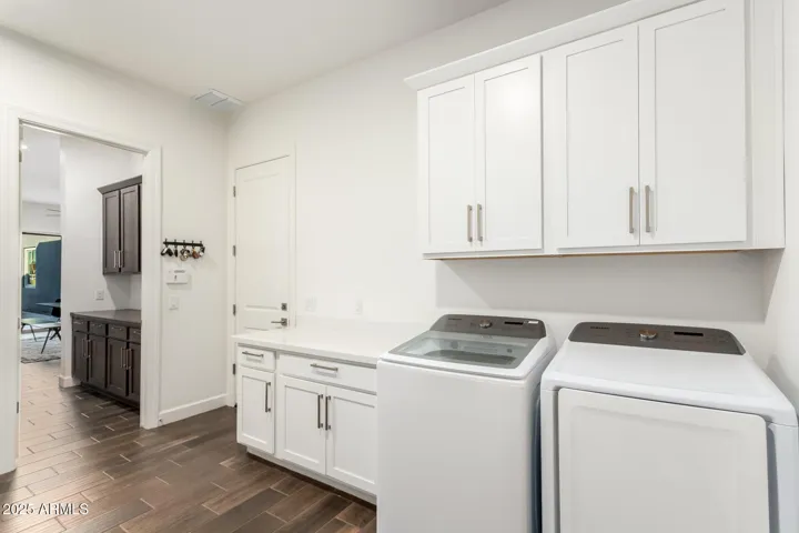 Spacious laundry room with extra cabinets, sink and counter space and separate single car garage door access