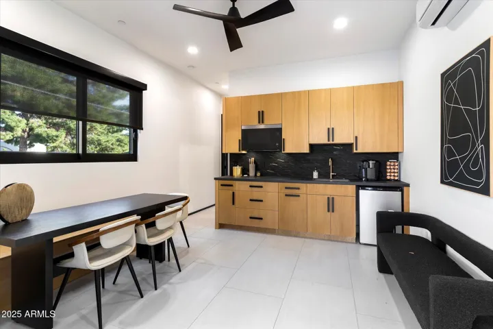 Living space and kitchen with sink, microwave/convection oven and fridge.