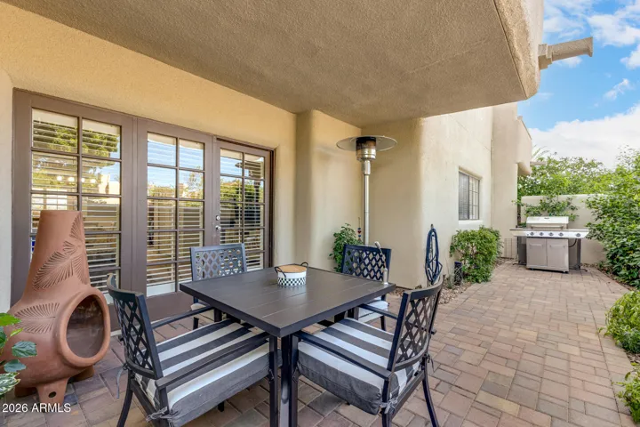 Covered patio with seating area, ideal for outdoor dining and relaxation.