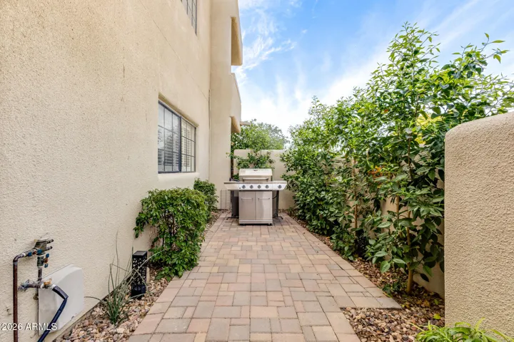 Private outdoor patio with paved flooring and surrounding greenery.