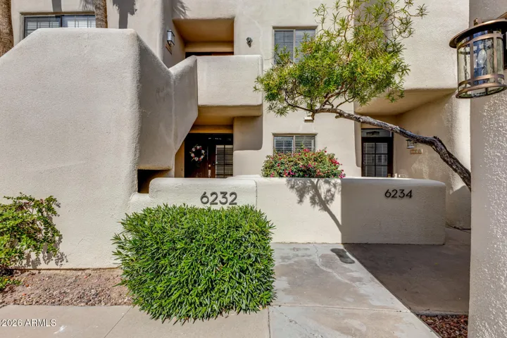 Exterior entry courtyard with landscaped walkway, stairs to main entrance, and well-maintained building façade.