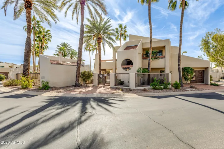 Exterior view of community buildings with desert landscaping and palm trees.