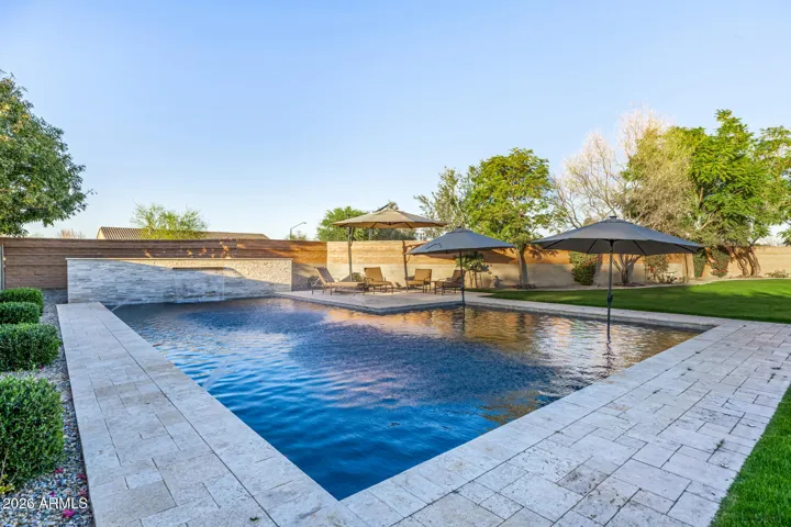 The 40x40 custom salt-water pool features a massive Baja step, LED lighting, Pentair equipment, and a stainless steel waterfall; all controllable remotely for effortless entertaining.