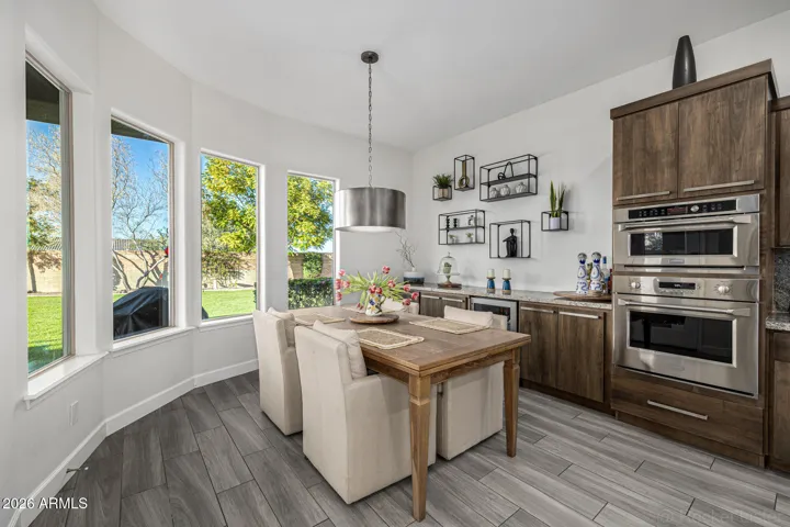 The breakfast nook invites relaxed mornings, weekend brunches, and casual conversations overlooking the backyard oasis.