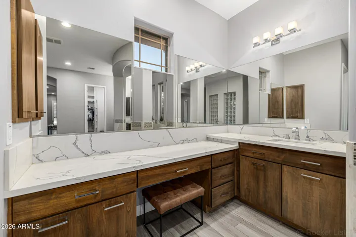 Large primary retreat with luxurious spa like bathroom featuring walk-in shower, soaking tub, dual sinks, separate vanity areas, granite counters, Restoration Hardware lighting and extended primary suite closet.