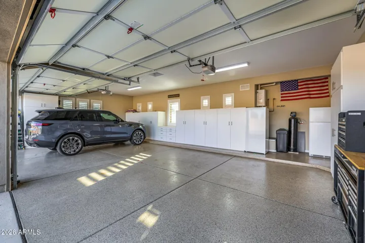 Expansive 4-car garage with Epoxy flooring and additional storage cabinets.