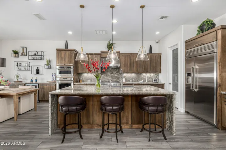 The heart of the home: where GE Monogram appliances, custom Alder cabinetry, and a dramatic waterfall island create a kitchen worthy of both quiet mornings and unforgettable dinner parties.