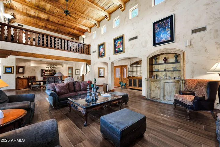 Soaring 19-Foot Ceilings, Clerestory Windows, and Southwestern Architecture Create a Stunning Entry Into the Living Room – With Wood-Beamed Ceilings, Stone Details, Natural Light, and Panoramic Mountain Views.