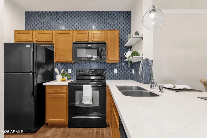 Designer tile wall and open shelving, quartz counters, maple cabinets