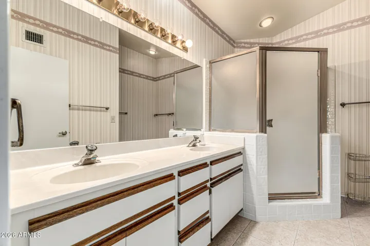 primary bathroom with dual vanities and walk in shower