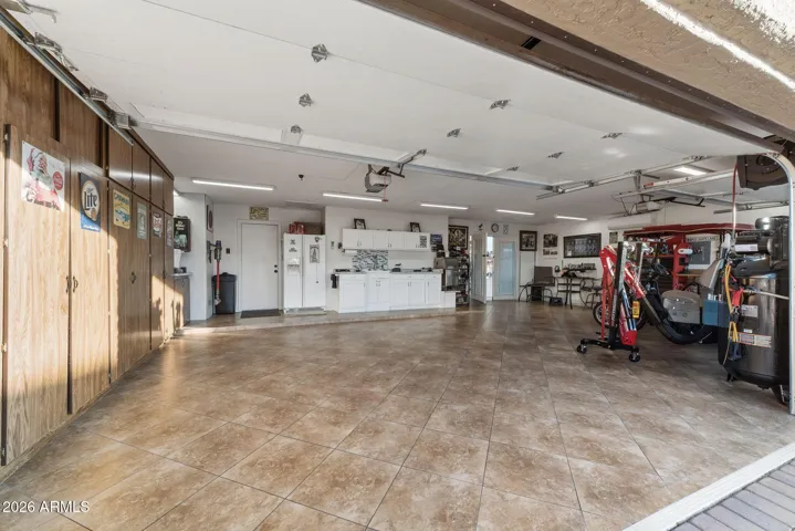 HUGE Full Length 3-Car Garage with built-in cabinets, counter space and refrigerator.